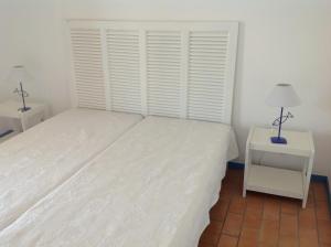 a bedroom with a large white bed and two lamps at Marina sur presqu’île des Capellans (Wifi) 6 couchages in Saint-Cyprien