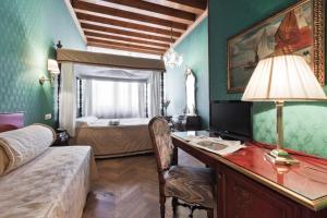 a bedroom with a desk with a computer and a bed at Palazzo Cendon Piano Antico in Venice