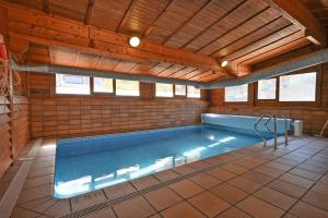 een zwembad in een kamer met een houten plafond bij Bungalows del Camping Pedraforca in Saldés