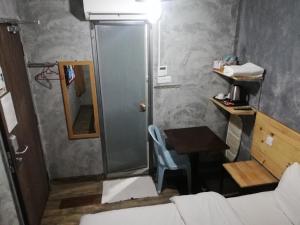 a bathroom with a shower and a table and a table and chair at Myera Hotel in Banting