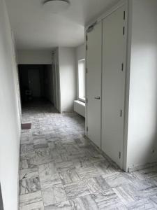 una stanza vuota con corridoio e pavimento piastrellato di Amajed a Namur