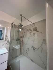 a bathroom with a shower with a marble wall at Amajed in Namur