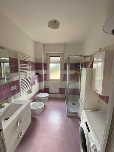bagno con 2 servizi igienici, 2 lavandini e una doccia di Coral Dream ad Alghero
