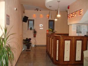 a lobby of a restaurant with a counter and plants at Hotel Lucy Star in Cluj-Napoca