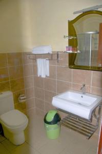 a bathroom with a sink and a toilet and a mirror at Nabalu Kundasang in Kundasang