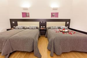 Habitación con 2 camas con rosas rojas. en Domus Best Guest House, en Roma