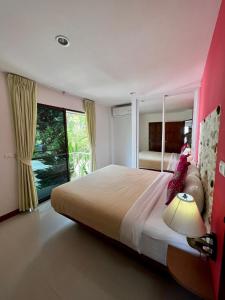 sypialnia z dużym łóżkiem i dużym oknem w obiekcie Mountain Seaview Luxury Apartments w mieście Kata Beach