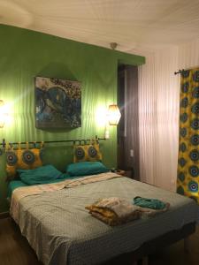 a bedroom with a bed with a green wall at Chambres vue imprenable in Guéréo