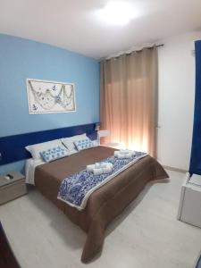 a bedroom with a large bed with blue walls at Ely Sea in Belvedere Marittimo