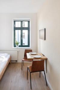 a room with a desk and a bed and a table and chair at TinyTiny modernes Studio Apartment in Plagwitz in Leipzig
