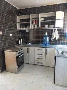 a kitchen with a sink and a stove at Wellstaycation in Bungoma