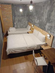 duas camas num quarto com uma mesa e uma cadeira em Myera Hotel em Banting