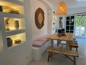 ein Esszimmer mit einem Tisch und einer Bank in der Unterkunft T3 Townhouse Old Village Vilamoura in Vilamoura