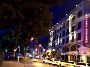Una calle de la ciudad con coches aparcados delante de un edificio. en Hotel Anibal, en Gebze