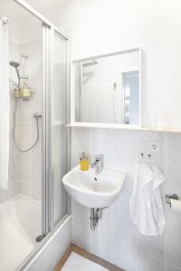 a white bathroom with a sink and a shower at TinyTiny modernes Studio Apartment in Plagwitz in Leipzig