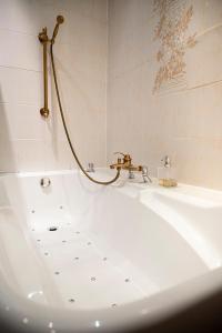 uma casa de banho com uma banheira e um lavatório em Hotel Du Parc - Manoir Du Baron Blanc em Faverges