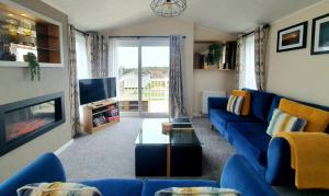 a living room with a blue couch and a tv at View point lodge in Newton on the Moor