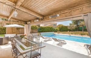eine Terrasse mit einem Tisch und Stühlen sowie einem Pool in der Unterkunft Villa Amelie in Saint-Cézaire-sur-Siagne