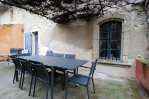 een zwarte tafel en stoelen voor een gebouw bij Gites Provence et Nature - séjours de rêve entre Luberon et Monts de Vaucluse in Cabrières-dʼAvignon