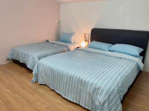 2 Betten nebeneinander in einem Zimmer in der Unterkunft Greenlane 4-bedroom landed home (12 pax) in Gelugor