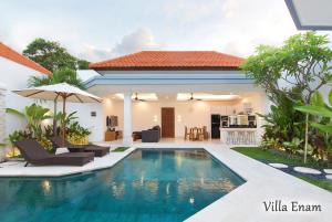 a villa with a swimming pool in front of a house at Villa Mia Seminyak - Boutique Villas in Seminyak
