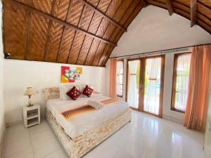 une chambre avec un lit dans une pièce avec des fenêtres dans l'établissement Gelih Bungalow Nusa Penida, à Nusa Penida 86 autres photos