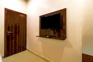 uma televisão de ecrã plano numa parede ao lado de uma porta em HOTEL SIGNATURE INN em Mumbai