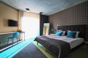 a bedroom with a large bed with blue pillows at Kurshi Hotel & Spa in Jūrmala
