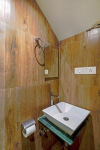 uma casa de banho com um lavatório branco e paredes de madeira em HOTEL SIGNATURE INN em Mumbai
