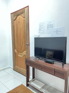 a television sitting on a table next to a door at D’Aliff Pamalan Homestay Keningau in Keningau