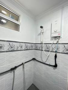 a shower in a bathroom with white tiled walls at D’Aliff Pamalan Homestay Keningau in Keningau