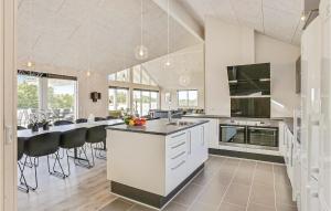 a large kitchen with a counter and a dining room at Lovely Home In Spttrup With Sauna in Lem