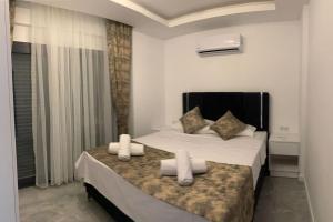 - une chambre avec un lit doté de draps et d'oreillers blancs dans l'établissement Nokta Park I 4+1 Villa, Özel Havuzlu, à Fethiye