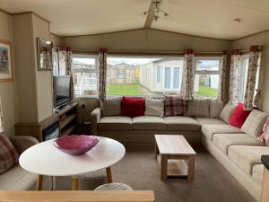 a living room with a couch and a table at Birchington vale caravan holiday park in Kent