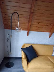 a lamp and a couch in a room with a ceiling at Bungalow Sud-Harz Bleicherode onder in Bleicherode
