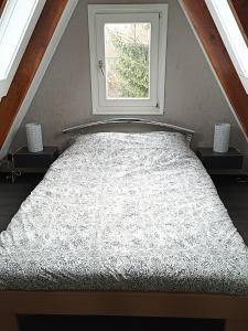 a bed in a room with a window at Bungalow Sud-Harz Bleicherode onder in Bleicherode