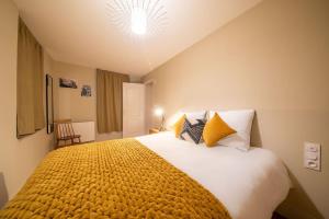 梅斯的住宿－La suite du Graou，一间卧室配有一张带黄色毯子的大床
