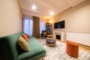 a living room with a green couch and a fireplace at La suite du Graou in Metz