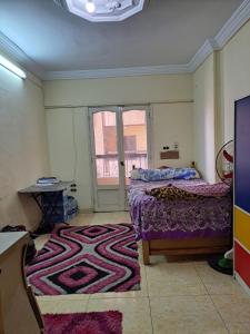 a bedroom with a bed and a rug on the floor at شقة مميزة في وسط بورسعيد 