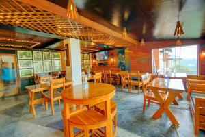 a dining room with wooden tables and chairs at FabHotel Dwaper in Mussoorie