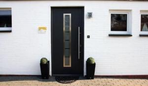 a black door on the side of a house at Bungalow 33 in Tossens in Tossenserdeich