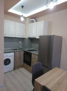 uma cozinha com um frigorífico de aço inoxidável e uma mesa em Прекрасен апартамент в София em Sófia