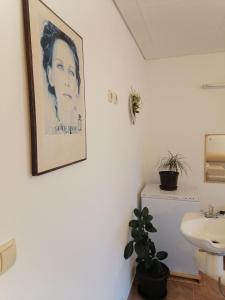 - une salle de bains avec une photo d'une femme sur le mur dans l'établissement Holiday home Filip i Petra, à Donji Proložac