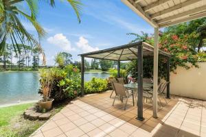 a patio with a table and chairs next to a lake at Tranquil Oasis on Pine Lake in Gold Coast