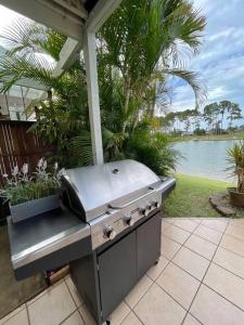 a grill sitting on a patio next to a lake at Tranquil Oasis on Pine Lake in Gold Coast