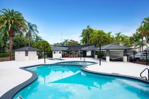a swimming pool at a resort with palm trees at Tranquil Oasis on Pine Lake in Gold Coast