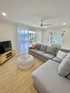 a living room with a couch and a tv at Tranquil Oasis on Pine Lake in Gold Coast
