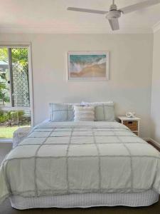 um quarto branco com uma cama grande e uma janela em Tranquil Oasis on Pine Lake em Gold Coast