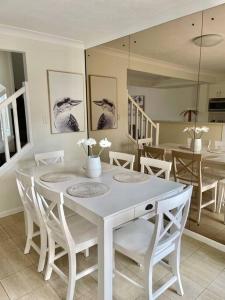 a dining room with a white table and chairs at Tranquil Oasis on Pine Lake in Gold Coast