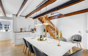 a kitchen and dining room with a white table and chairs at Stunning Apartment In Gudhjem in Gudhjem